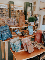 bags and shoes set on an orange and wood table in the middle of birkenstock village showroom in santa rosa, ca